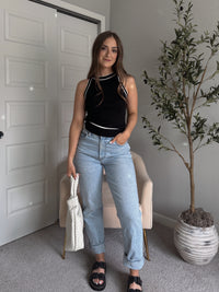 Model wearing the Jolie Contrast Trim Knit Halter Top in black with white piping, styled with light wash jeans, spring outfit
