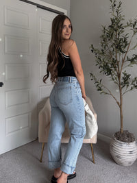 Model wearing the Jolie Contrast Trim Knit Halter Top in black with white piping, styled with light wash jeans, spring outfit
