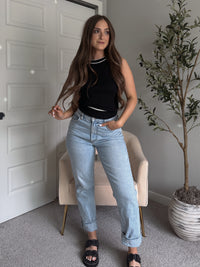 Model wearing the Jolie Contrast Trim Knit Halter Top in black with white piping, styled with light wash jeans, spring outfit
