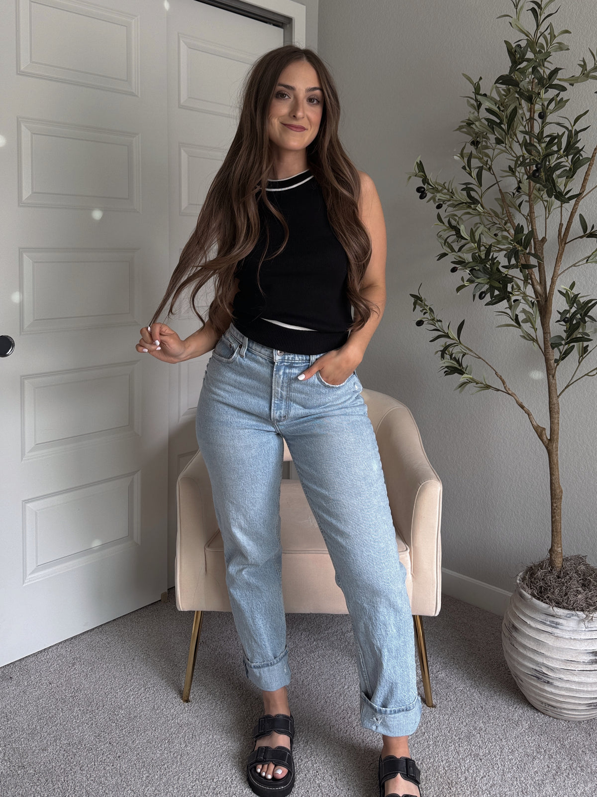Model wearing the Jolie Contrast Trim Knit Halter Top in black with white piping, styled with light wash jeans, spring outfit