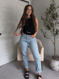 Model wearing the Jolie Contrast Trim Knit Halter Top in black with white piping, styled with light wash jeans, spring outfit