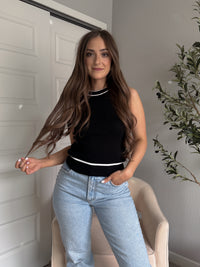 Model wearing the Jolie Contrast Trim Knit Halter Top in black with white piping, styled with light wash jeans, spring outfit