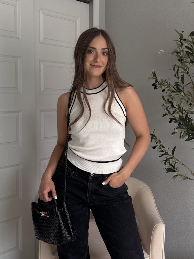 Model wearing the Jolie Contrast Trim Knit Halter Top in ivory with black piping, styled with black wash jeans, spring outfit