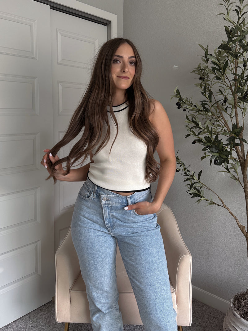 Model wearing the Jolie Contrast Trim Knit Halter Top in ivory with black piping, styled with light wash jeans, spring outfit