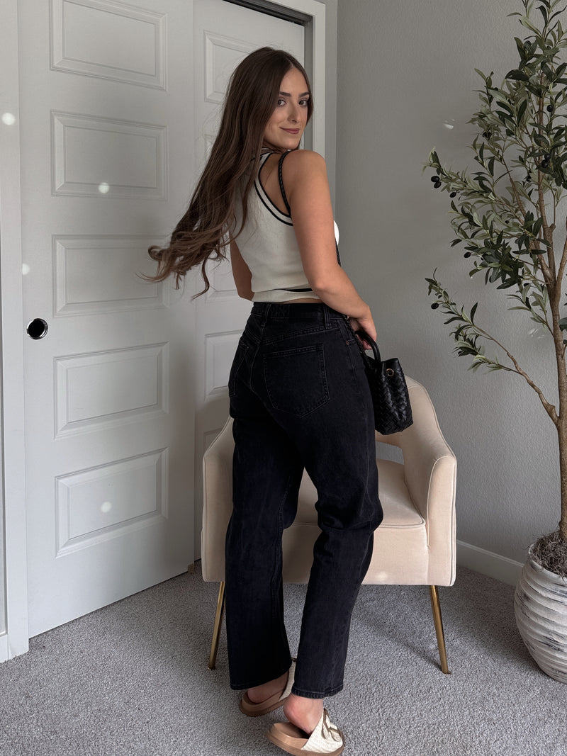 Model wearing the Jolie Contrast Trim Knit Halter Top in ivory with black piping, styled with black wash jeans, spring outfit