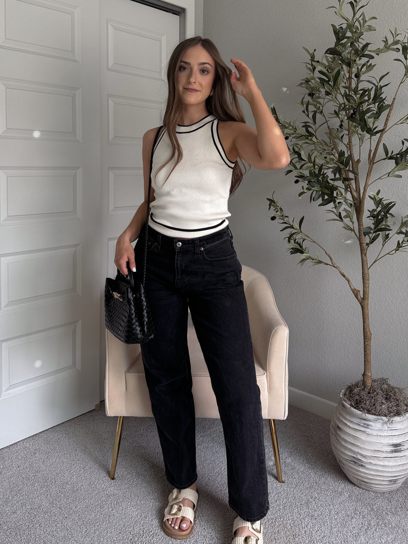 Model wearing the Jolie Contrast Trim Knit Halter Top in ivory with black piping, styled with black wash jeans, spring outfit